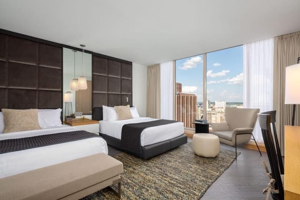 Recharge in a bright double-queen room with skyline light.