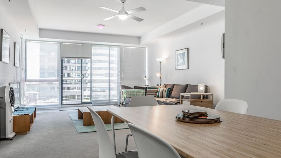 Spacious living and dining area with floor to ceiling windows and city outlooks, creating a bright and inviting atmosphere.