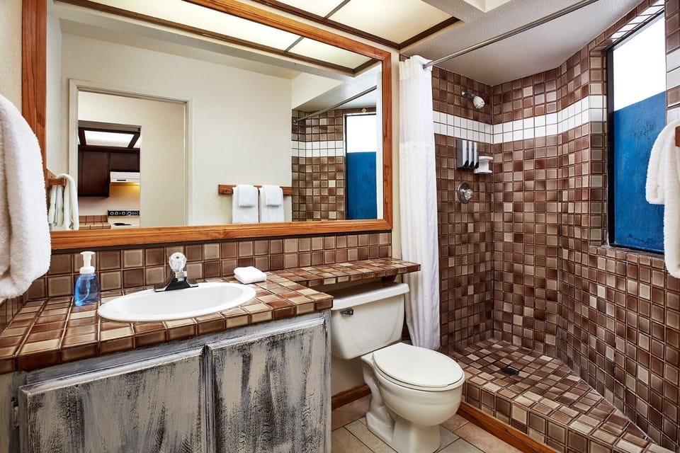 Refresh in a spacious tiled shower with bright vanity mirror.