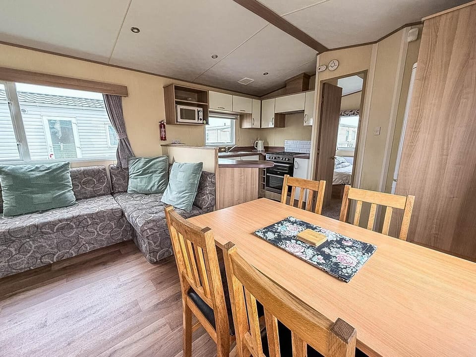 The spacious dining table provides the perfect spot for family meals, games, and sharing stories after a day at the seaside