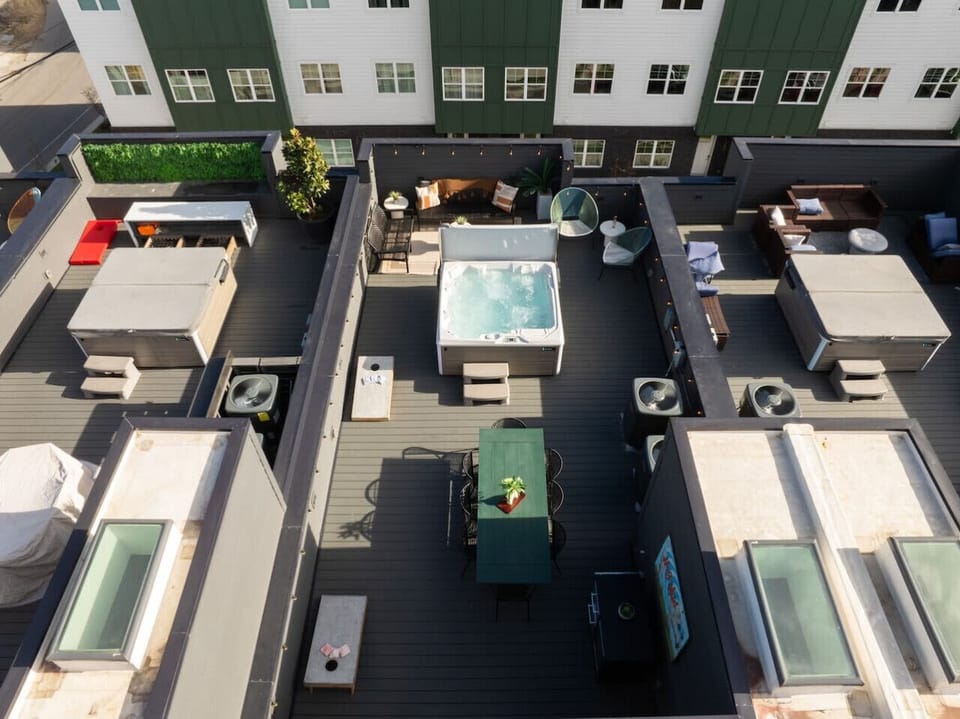 Rooftop patio with a hot tub, dining area, and lounge seating.