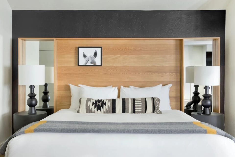 Sink into crisp linens beneath a bold, modern headboard.