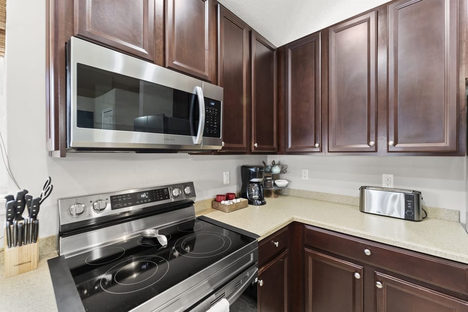 Kitchen with stainless steel appliances and dark wood cabinetry for a sleek modern touch