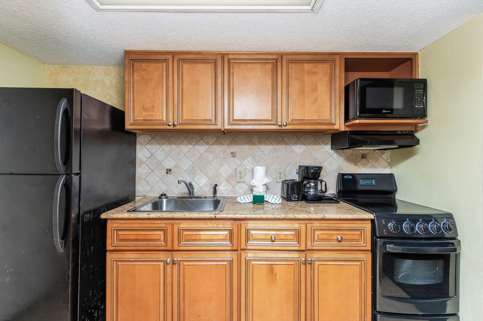 Fully equipped cooking space with oven, range, and microwave.