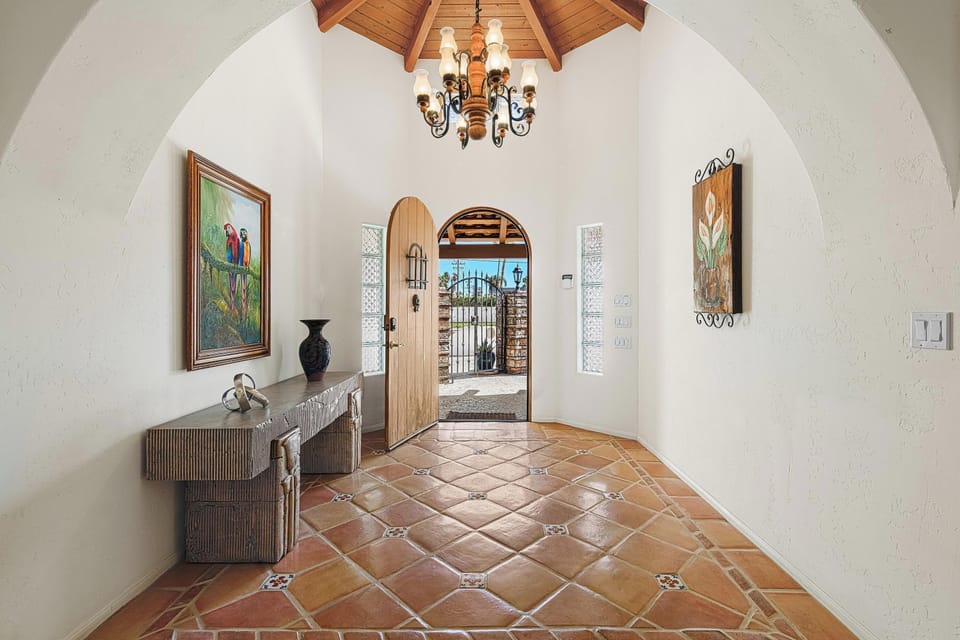 Grand rotunda foyer with artisan wood ceiling, arched doorway and rounded walls