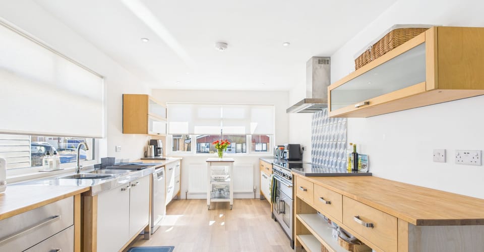 A high-spec luxury kitchen featuring a central island, induction hob, and integrated appliances.