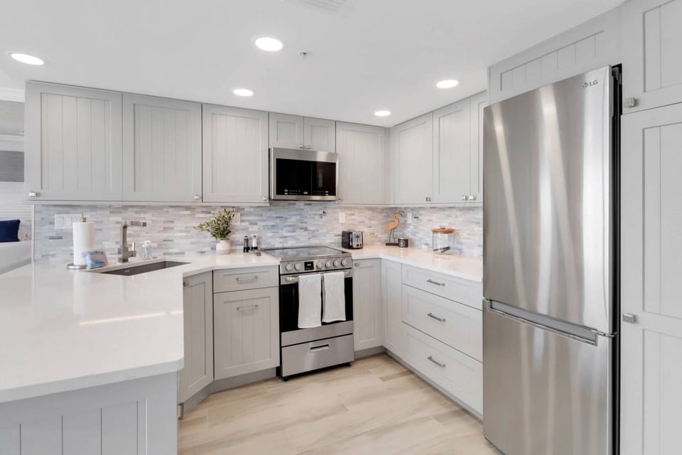 The open kitchen has been completely remodeled with quartz counters, upgraded cabinetry and appliances.