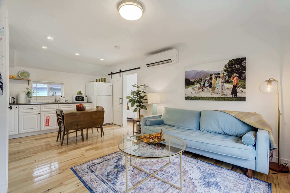 Bright and inviting living space with stylish decor, a comfortable sofa, and an open-concept layout connecting to the kitchen.





