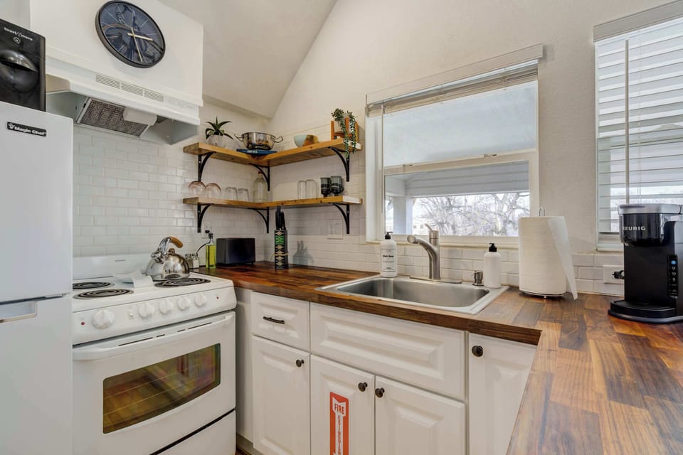 The kitchen combines style and function, featuring butcher block countertops, open shelving, and all the essentials needed for a convenient stay.






