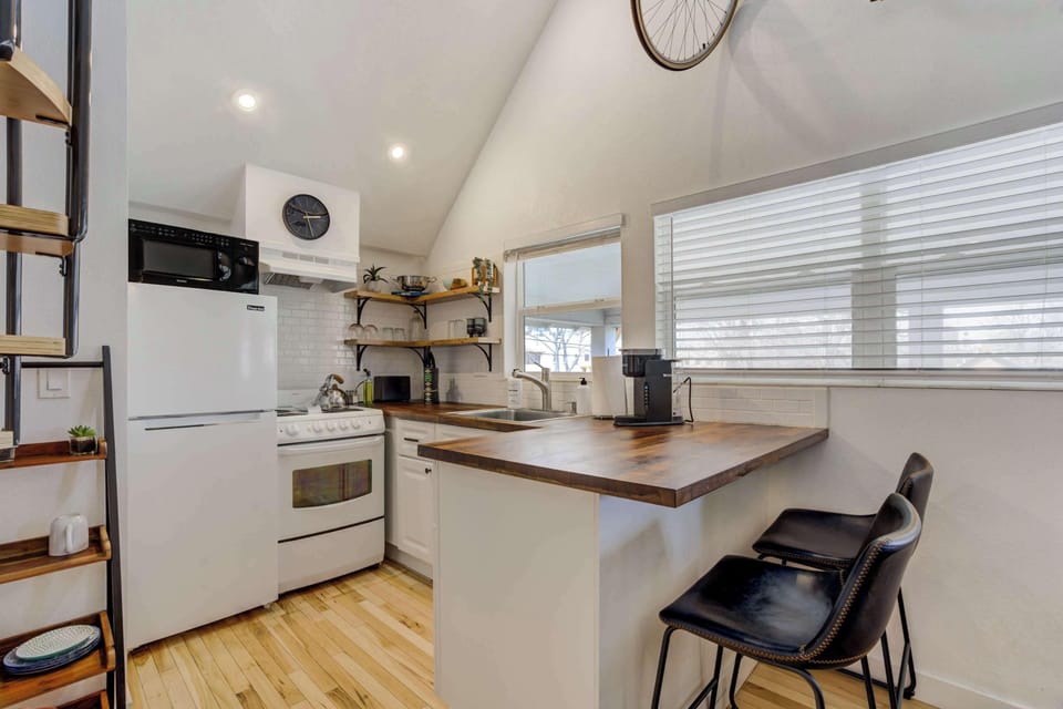 Compact yet fully equipped kitchen with modern appliances, open shelving, and a cozy breakfast bar for casual dining.





