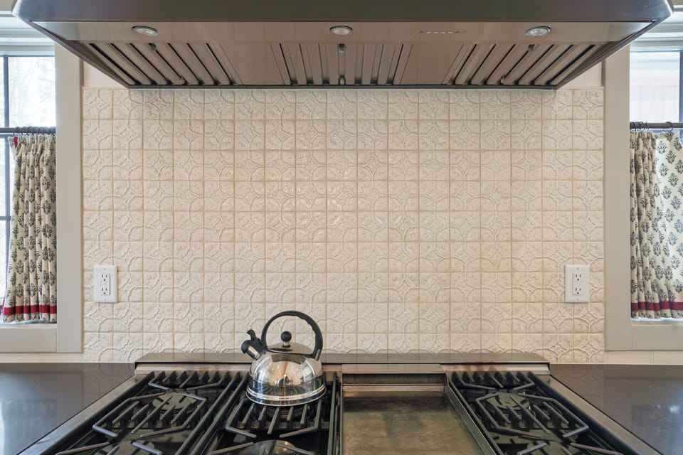 Beautiful gas range with custom backsplash.