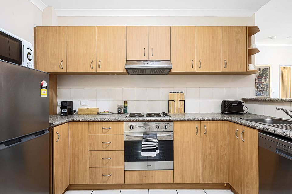 Cook with ease in a well-equipped kitchen, featuring ample wooden cabinetry, modern appliances, and plenty of counter space.