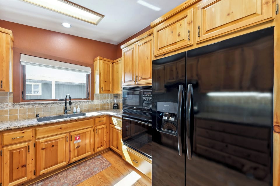 Your fully-equipped kitchen awaits with warm wood cabinets, granite counters, and full-sized appliances—perfect for preparing memorable meals.