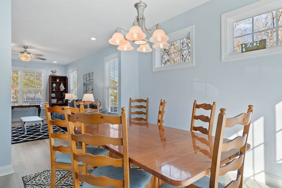 Gather around your spacious dining table where warm wood tones and soft blue walls create the perfect setting for memorable meals together.