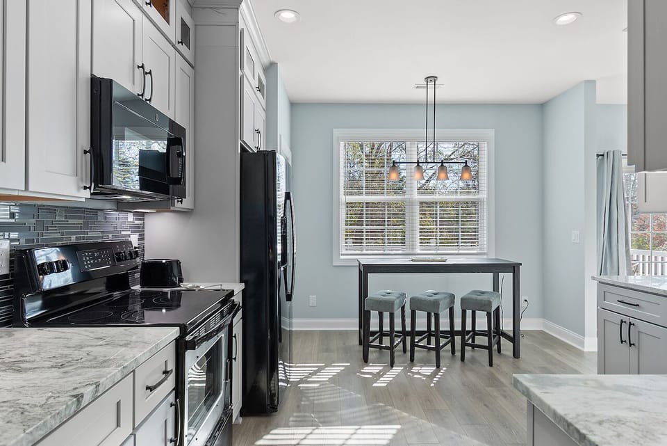 Your bright kitchen features marble countertops, modern appliances, and a cozy breakfast island where you can enjoy morning coffee.