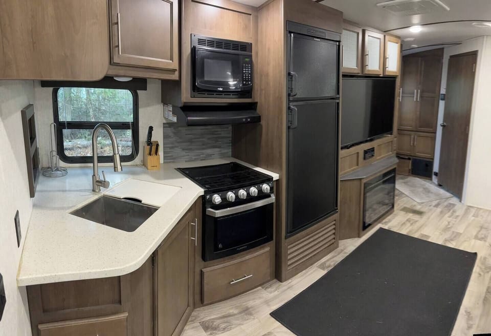 Kitchen is equipped with fridge, freezer, stove top, oven microwave, coffee maker.