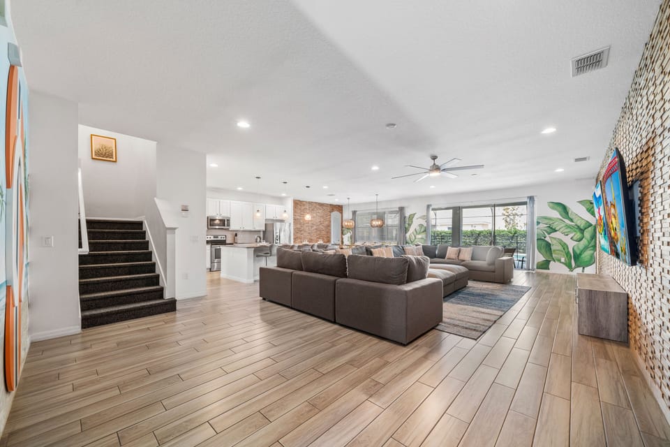 - Spacious open living room with sectional sofa for families  
- Bright vacation rental near Disney with TV and feature wall  
- Perfect Orlando group stay with modern open floor layout