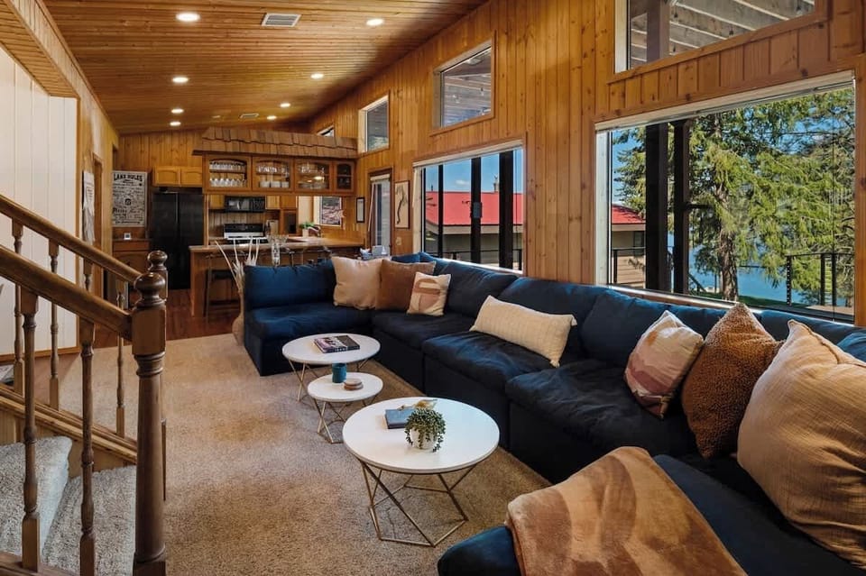 A cozy lakeside living area with plush seating, warm wood accents, and stunning views through expansive windows.