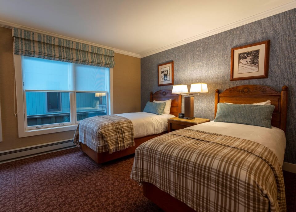 Sleep comfortably in twin beds with soft lighting and cozy textiles.