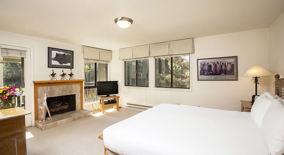 Unwind in this spacious bedroom with a cozy fireplace glow.