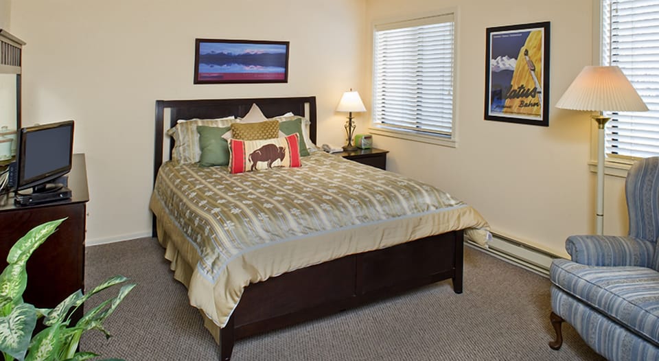Recharge in a cozy bedroom with reading lamp and comfy chair.