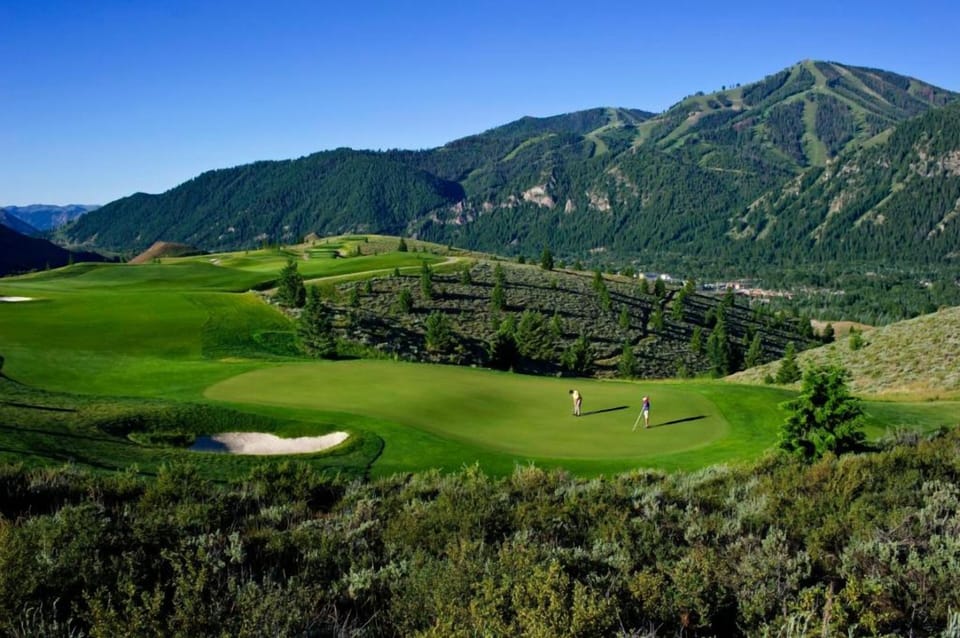 Tee off on sweeping greens with breathtaking mountain backdrops