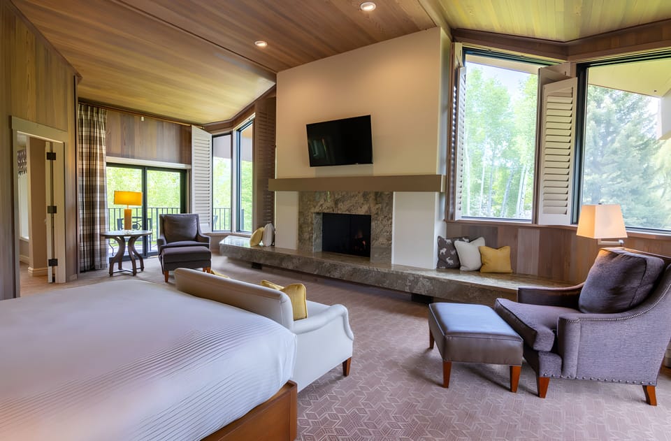 Unwind in a sunlit suite with fireplace and lounge seating.