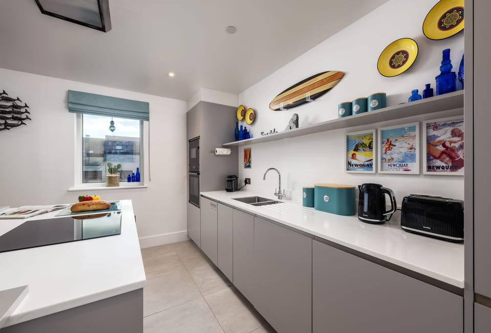 1 Cliff Edge, Newquay: The kitchen is fully equipped kitchen with modern appliances, including a wine fridge, induction hob, and remote-controlled extractor fan
