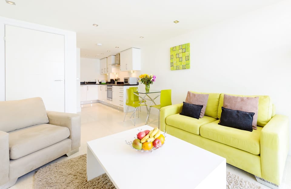 28 Rocklands, Newquay: Sitting room with two-seater sofa, which doubles up as a sofa bed on request, armchair, Smart television and large floor to ceiling windows showing off sea views