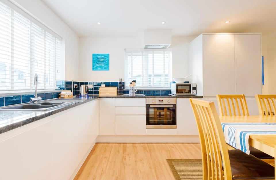 Fistral Palms 2, Newquay: The sleek kitchen is superbly equipped with  an electric oven and induction hob, fridge/freezer, microwave, and dishwasher