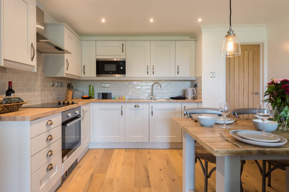Sandcastles 11 Europa Court, Mawgan Porth: Charming kitchen with an  electric oven and hob, fridge, microwave and dishwasher