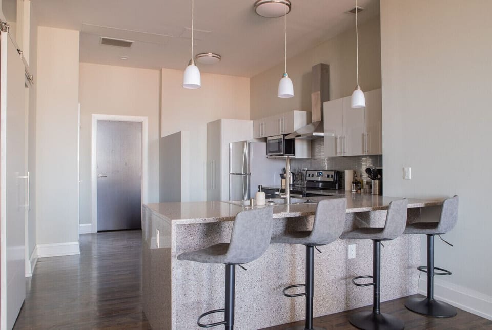 A fully-equipped kitchen featuring high-end finishes and bar seating—everything you need to prep, cook, and refuel