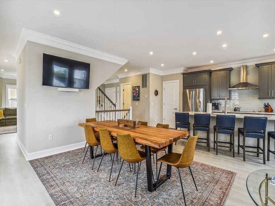 Open-concept dining and kitchen area, featuring a mounted TV for a relaxed dining experience.