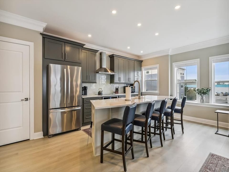 Modern kitchen with stainless steel appliances, a large island, and ample seating for gathering.