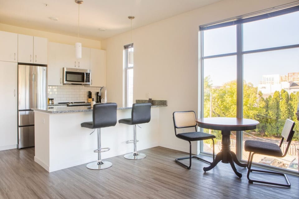A sun-drenched dining area that doubles as a spacious workstation—perfect for remote work or a morning coffee