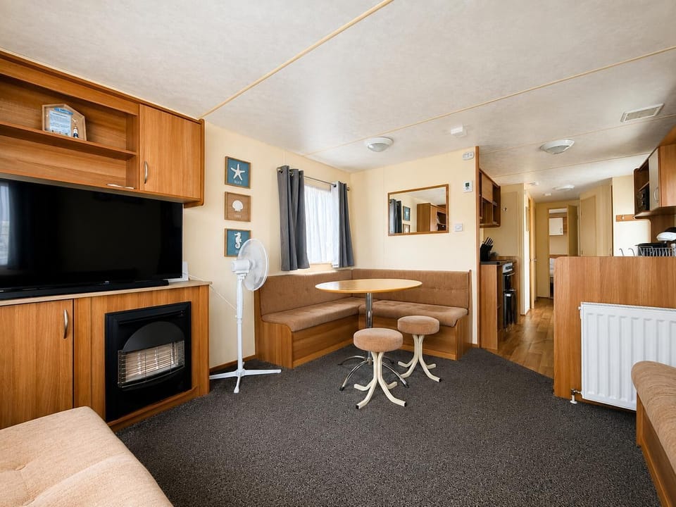 The holiday home living room is designed with comfort in mind, featuring a large sofa and a fireplace.