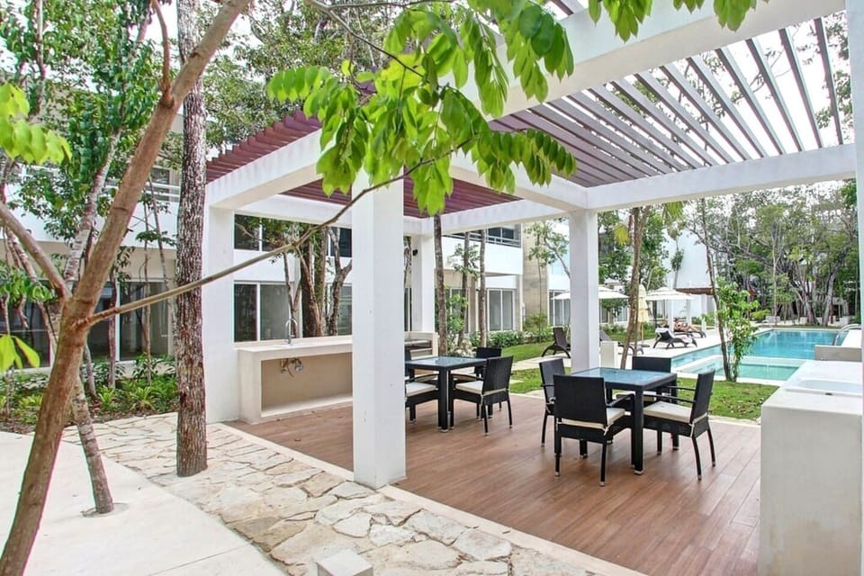 Step into our patio oasis with cozy chairs, BBQ grill, and sink.