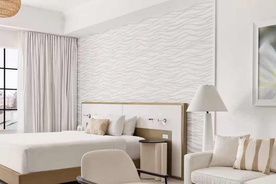 Unwind in a sunlit suite with crisp linens and calm tones.