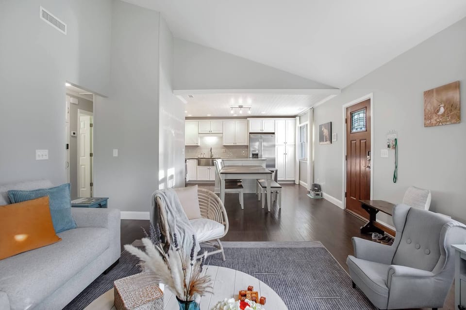 Step into comfort at The Sunny Refuge—where the open living space flows effortlessly into a modern kitchen and dining area, perfect for relaxing or entertaining.
