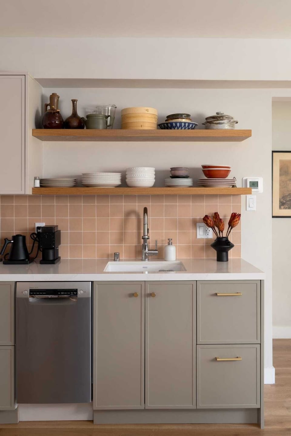 This charming kitchenette features open wood shelving, warm tile accents, a modern sink, and sleek appliances—perfectly designed for preparing easy meals during your stay