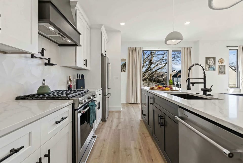 Modern kitchen with a gas stove and wide counter space, built for groups who like to cook together and keep tabs on the game room action just steps away