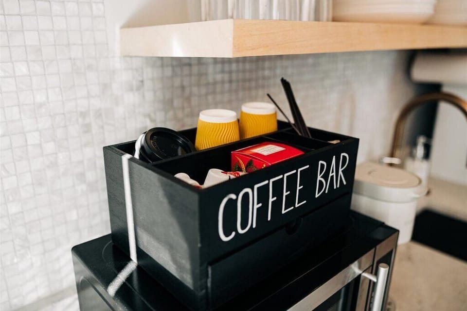 The coffee bar is stocked with with a variety of tea and coffee pods, creamer/sweetener options, and even to-go cups!