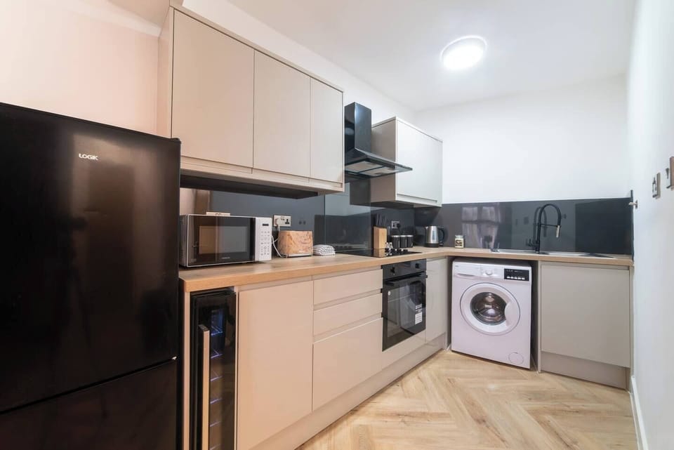 A spacious open-plan kitchen equipped with modern appliances and a washing machine—perfect for longer stays.