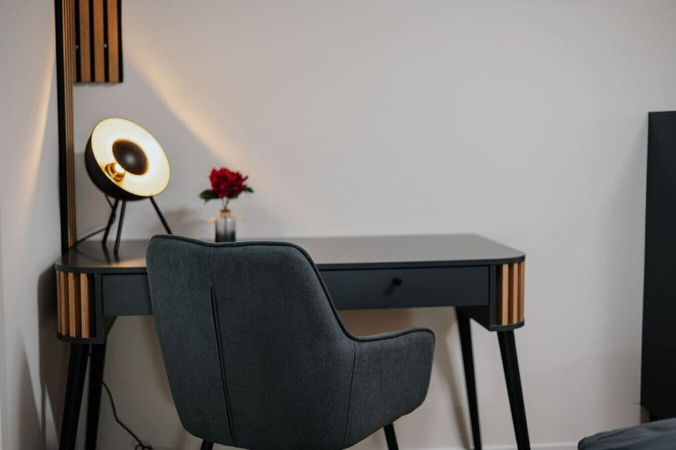 The apartment features a desk with a lamp.