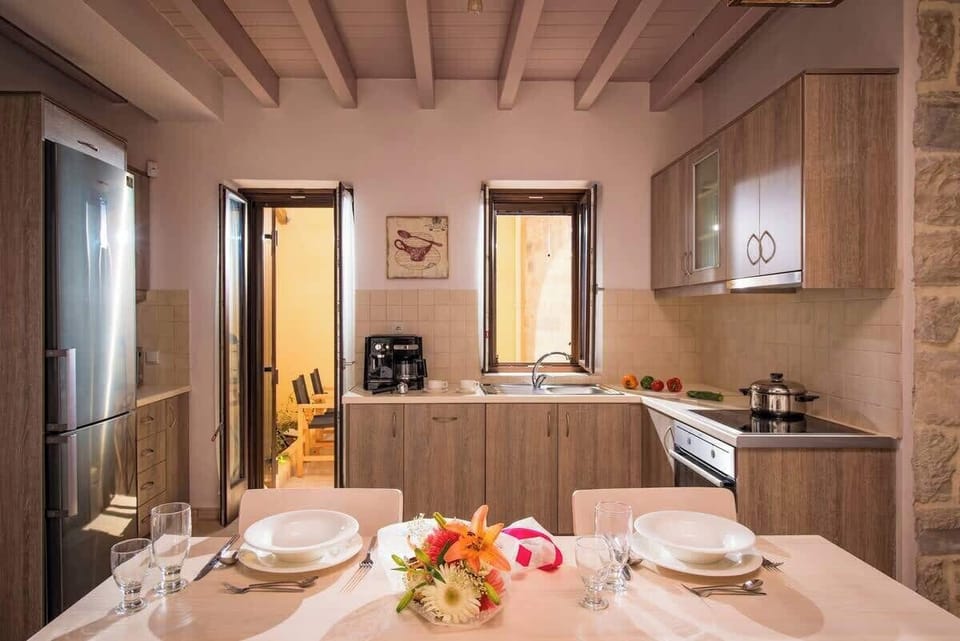 Villa Dafne – Dining Area and Kitchen – Open and inviting setting for shared meals with natural light and earthy details.