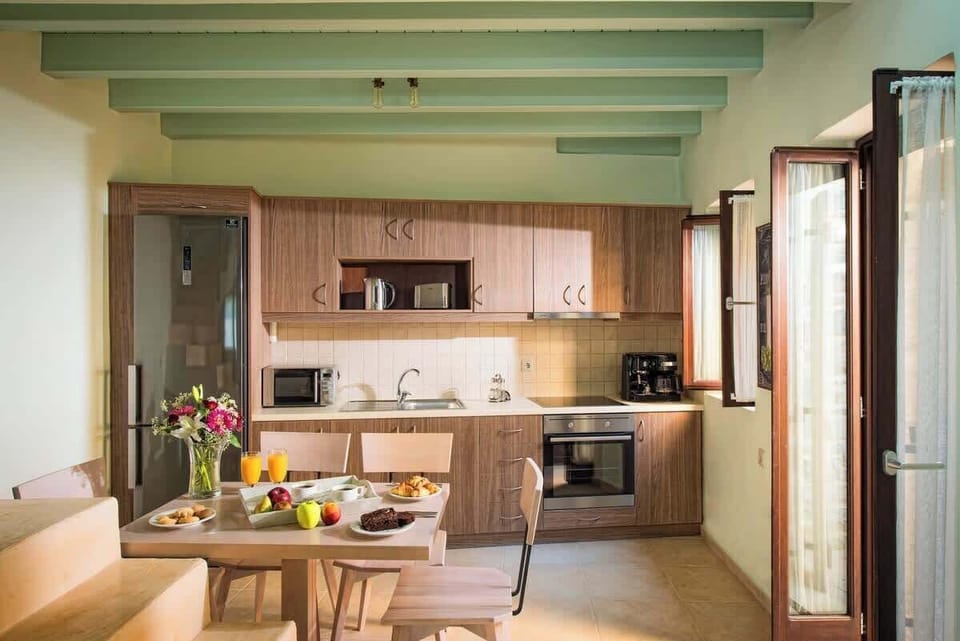 Villa Kastalia – Dining Area and Kitchen – Inviting open-plan space designed for shared meals, combining modern function with rustic beauty.