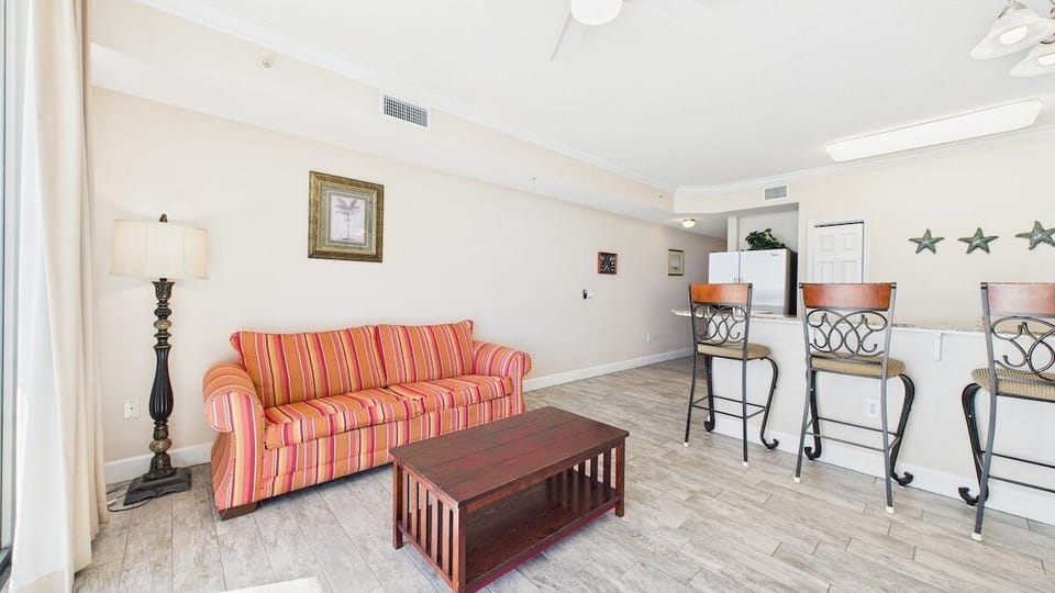 Open concept living area with TV sleeper sofa and gulf views
