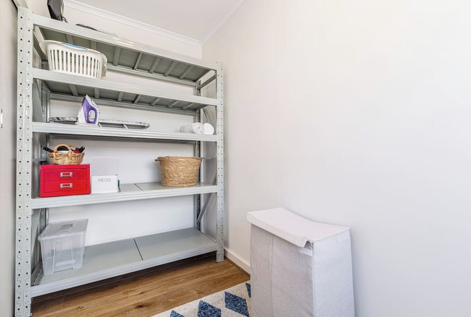 Stay organised with open shelving, neatly stocked with office supplies, an iron and a laundry hamper for added convenience during your stay.