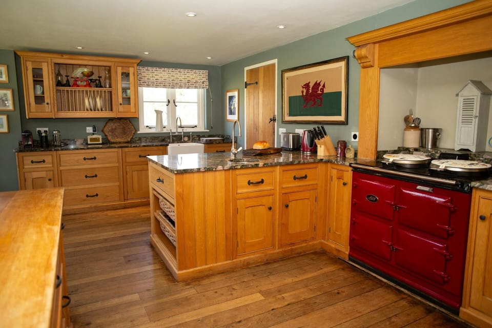 Kitchen with Aga, base and wall units, toaster, kettle, cafetiere, knife block, small sink and ceramic butler sink