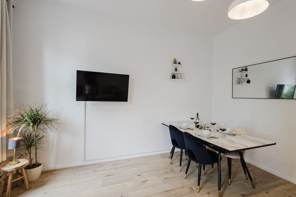 A bright dining corner with cozy lighting, decorative shelving, and a smart TV – designed for memorable evenings.